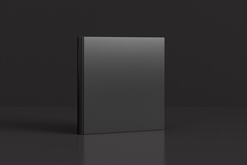 Hardcover square black mockup book standing on the black background.