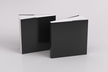 Two softcover or paperback square black mockup books standing on the white background. Blank front and back cover