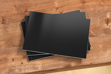 Horizontal or landscape black magazine or brochure stack mockup on wooden table.