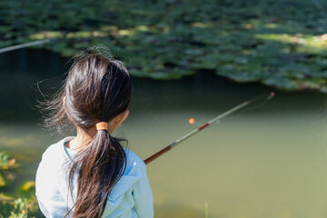 釣り堀で魚釣りをする女の子