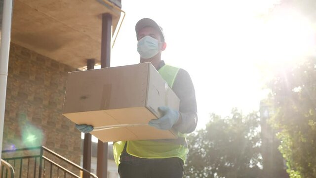 delivery pandemic coronavirus vaccine a goods and food product. courier delivery man covid delivers food to your home. parcel delivery concept. courier carries box warehouse coronavirus office boy