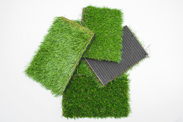 Sample pieces of green artificial grass of different thickness.