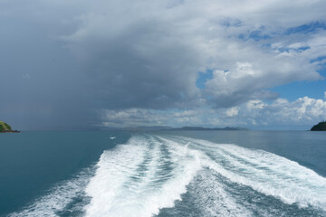 Wake of a ship in the ocean with storm clouds approaching