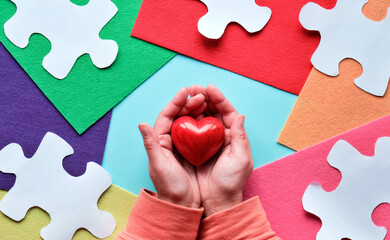 Creative design for Autism World day, April 2. Panoramic awareness banner, hands hold red heart.