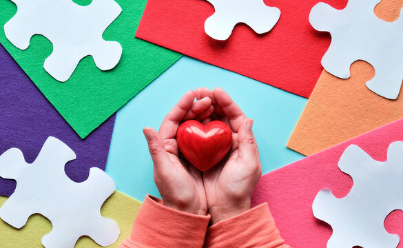 Creative design for Autism World day, April 2. Panoramic awareness banner, hands hold red heart.