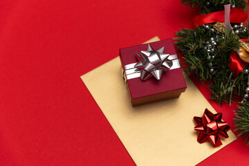 red little gift on a red background with a silver bow with Christmas decorations
