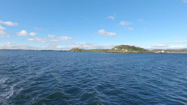 A boat floating in front of Inchcolm Island, Firth of Forth, Scotland
