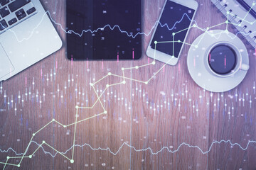 Multi exposure of forex graph hologram over desktop with phone. Top view. Mobile trade platform concept.