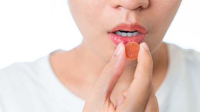 Close up of asian woman holding medical melatonin yelly for cure chronic insomnia isolate on white background.