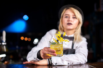 Girl barman formulates a cocktail on the pothouse