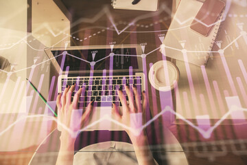 Double exposure of woman hands working on computer and forex chart hologram drawing. Top View. Financial analysis concept.