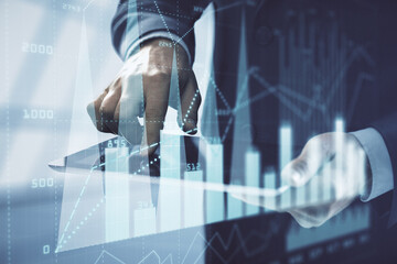 Double exposure of man's hands holding and using a digital device and forex graph drawing. Financial market concept.
