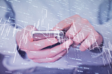 Double exposure of man's hands holding and using a digital device and forex graph drawing. Financial market concept.