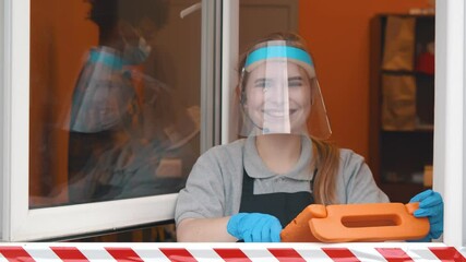 Fast food cashier with tablet and headset in drive thru service wearing face shield and glasses