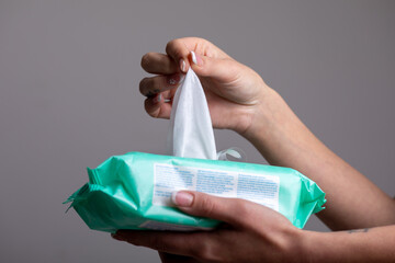 Taking baby wet wipes from the packaging - hygiene procedure and prevention of infectious diseases - obrazy, fototapety, plakaty