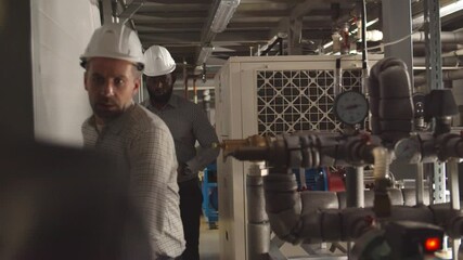 Factory workers evacuating during emergency situation with alarm lights on