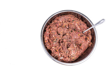 Overhead view on minced preparation of barf raw food recipe for dogs consisting meat, organs, fish, eggs and vegetable