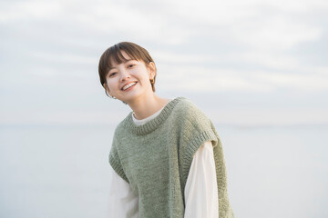 夕方、海をバックに撮影された若い女性のポートレート