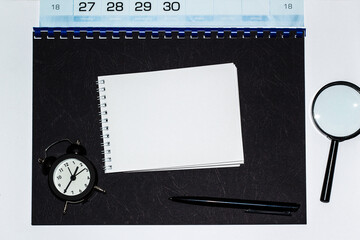 notebooks, watch and a pen on the table for information on a black background . A place for text. Business, marketing, financial concept