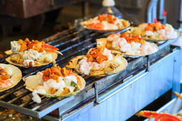 grilled seafood on seashell , japanese street food at Tsukiji Fish Market, Japan. selective focus