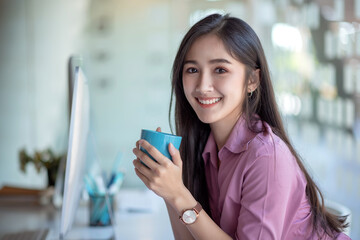 Young asian business woman beautiful charming smiling and drinking coffee in office. Looking at camera.