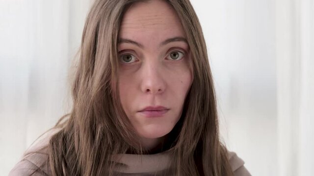 Woman sniffing lemon and does not smell due to illness shakes her head at home curtains