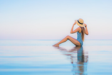 Portrait beautiful young asian woman relax smile leisure around outdoor swimming pool nearly sea