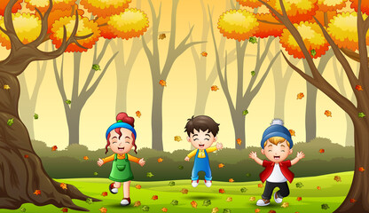 Happy kids having fun and playing with autumn leaves in forest