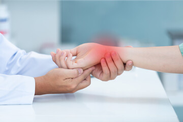 Close up doctor examining patient with wrist bone problems painful wrist caused by prolonged work...