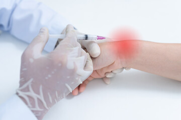 close up doctor or nurse hands with syringe injecting to wrist medical. Wrist bone problems painful...