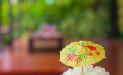 Paper umbrella on the dining table with a blurry background.