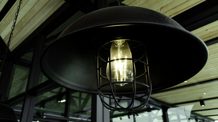 Incandescent lamp shining in cafe restaurent, Yellow light of lamp hang on ceiling