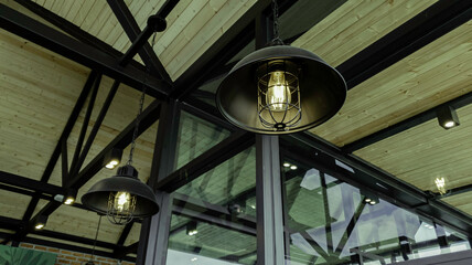 Fototapeta na wymiar Incandescent lamp shining in cafe restaurent, Yellow light of lamp hang on ceiling