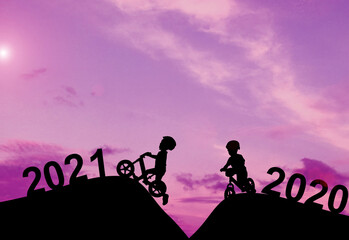 Obraz na płótnie Canvas Silhouette boy Jump spin bike In the evening atmosphere Sunset.Concept New Year's Eve 2020 Welcome the new year 2021.