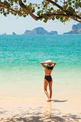 Woman in swimsuit and hat on the beach, Krabi, Thailand. - 394059008