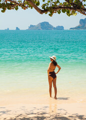 Woman in swimsuit and hat on the beach, Krabi, Thailand. - 394059022