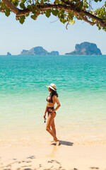 Woman in swimsuit and hat on the beach, Krabi, Thailand. - 394059038