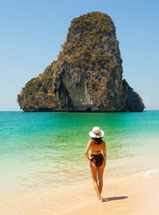 Woman in swimsuit and hat on the beach, Krabi, Thailand. - 394059040