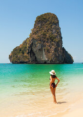Woman in swimsuit and hat on the beach, Krabi, Thailand. - 394059051