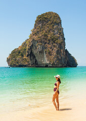 Woman in swimsuit and hat on the beach, Krabi, Thailand. - 394059056