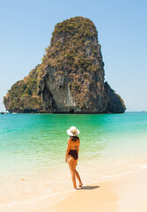 Woman in swimsuit and hat on the beach, Krabi, Thailand. - 394059079