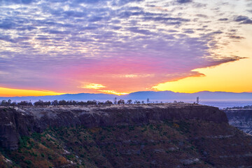 Sunset in California Mountains with orange skies and white and blue skies. Lookout Point Paradise California.   