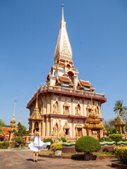 Woman in white dress and Wat Chalong temple, Phuket, Thailand. - 394059643