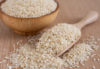 White sesame on wooden background.