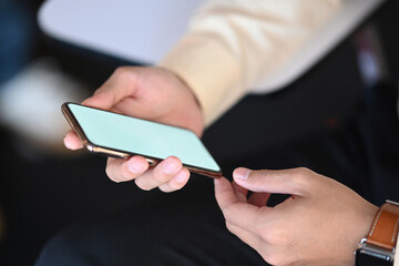 Close up shot of man hands holding mobile phone. Blank screen for graphic display montage.