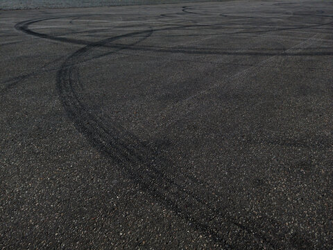 The concept of street racing and drifting on grey asphalt - car tire marks on the asphalt