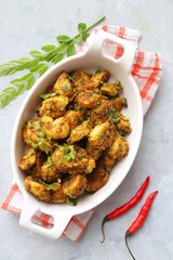 Stir fried taro roots. Arbi ki sabji, Taro roots masala curry. Arbi Masala. Garnished with coriander, red chili & curry leaves. copy space.