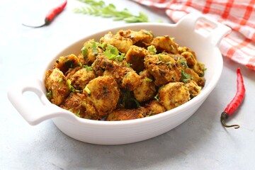 Stir fried taro roots. Arbi ki sabji, Taro roots masala curry. Arbi Masala. Garnished with coriander, red chili & curry leaves. copy space.