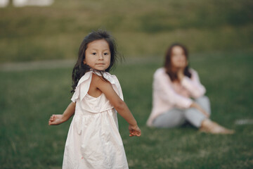 Beautiful family in a park. Woman in a blouse. Mother with daughter.