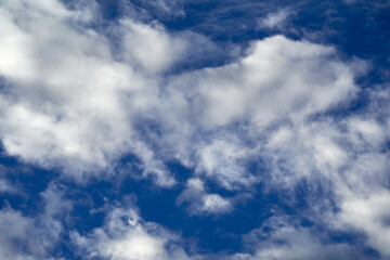 Naklejka premium Beautiful sky with white cumuls clouds against a blue background. up view.